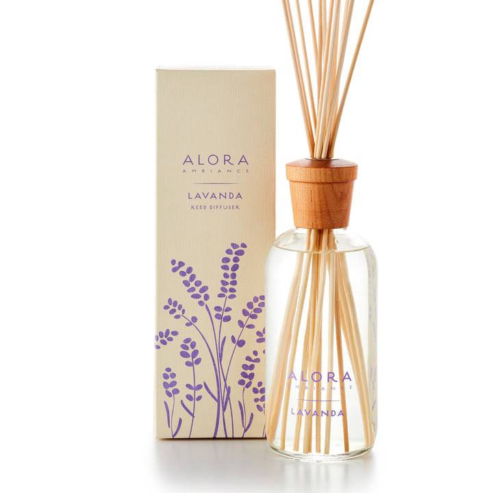Alora Ambiance 16oz Lavanda reed diffuser with glass bottle and wooden cap next to tan box with purple lavender pattern on it.