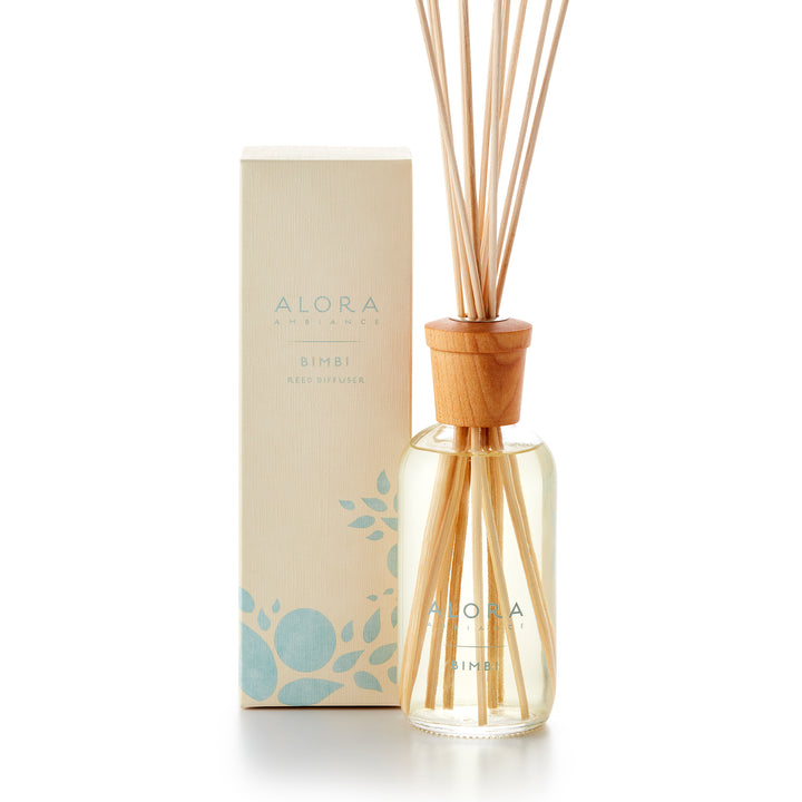 Alora Ambiance 8oz Bimbi reed diffuser with glass bottle and wooden cap next to tan box with baby blue floral pattern on it.