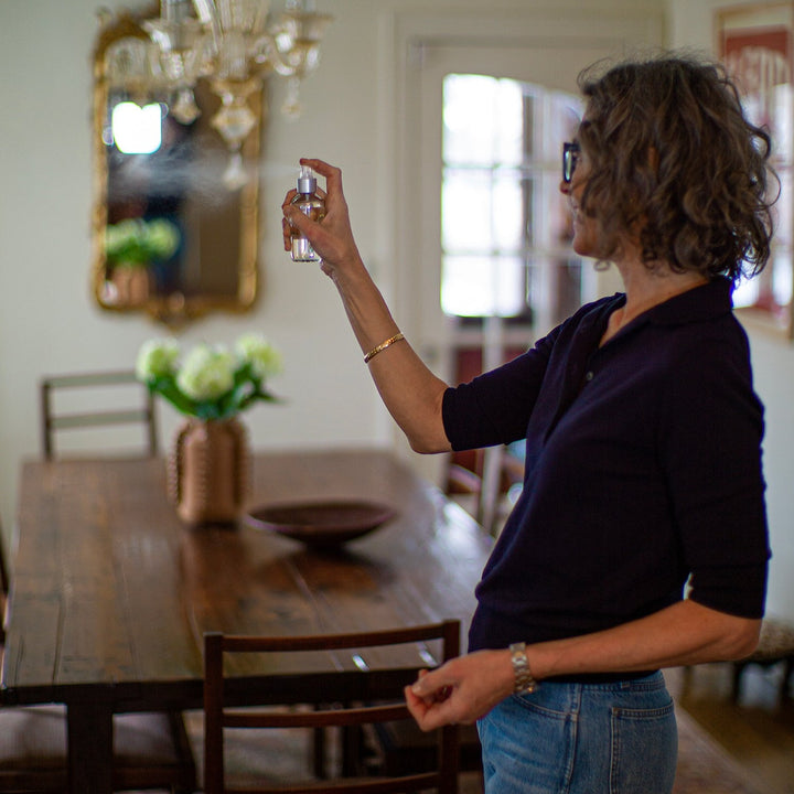 Woman spritzing room spray in dining room