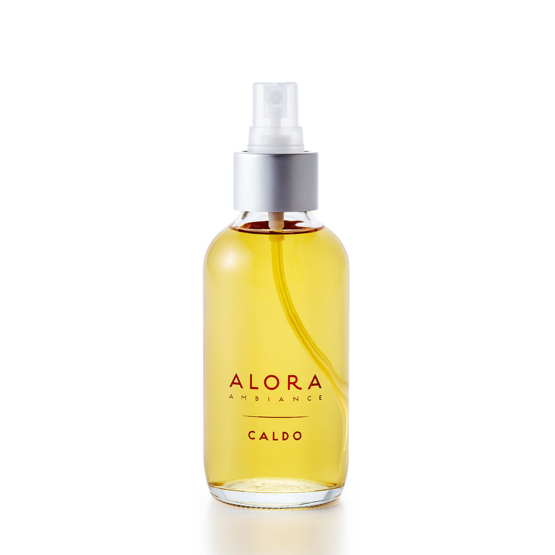 Glass spray bottle with the words "Alora Ambiance" and "Caldo" on the front
