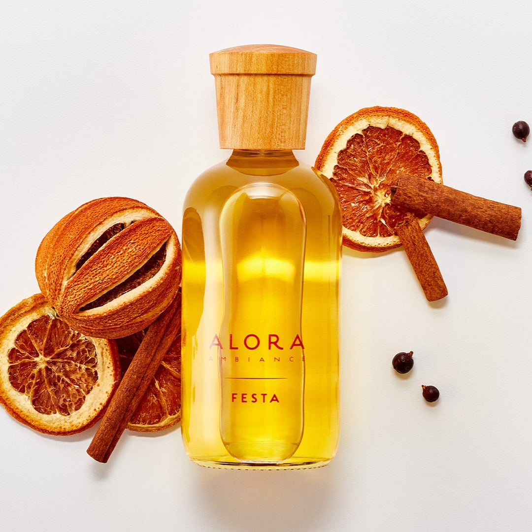 Festa diffuser bottle laying by dried orange slices and cinnamon