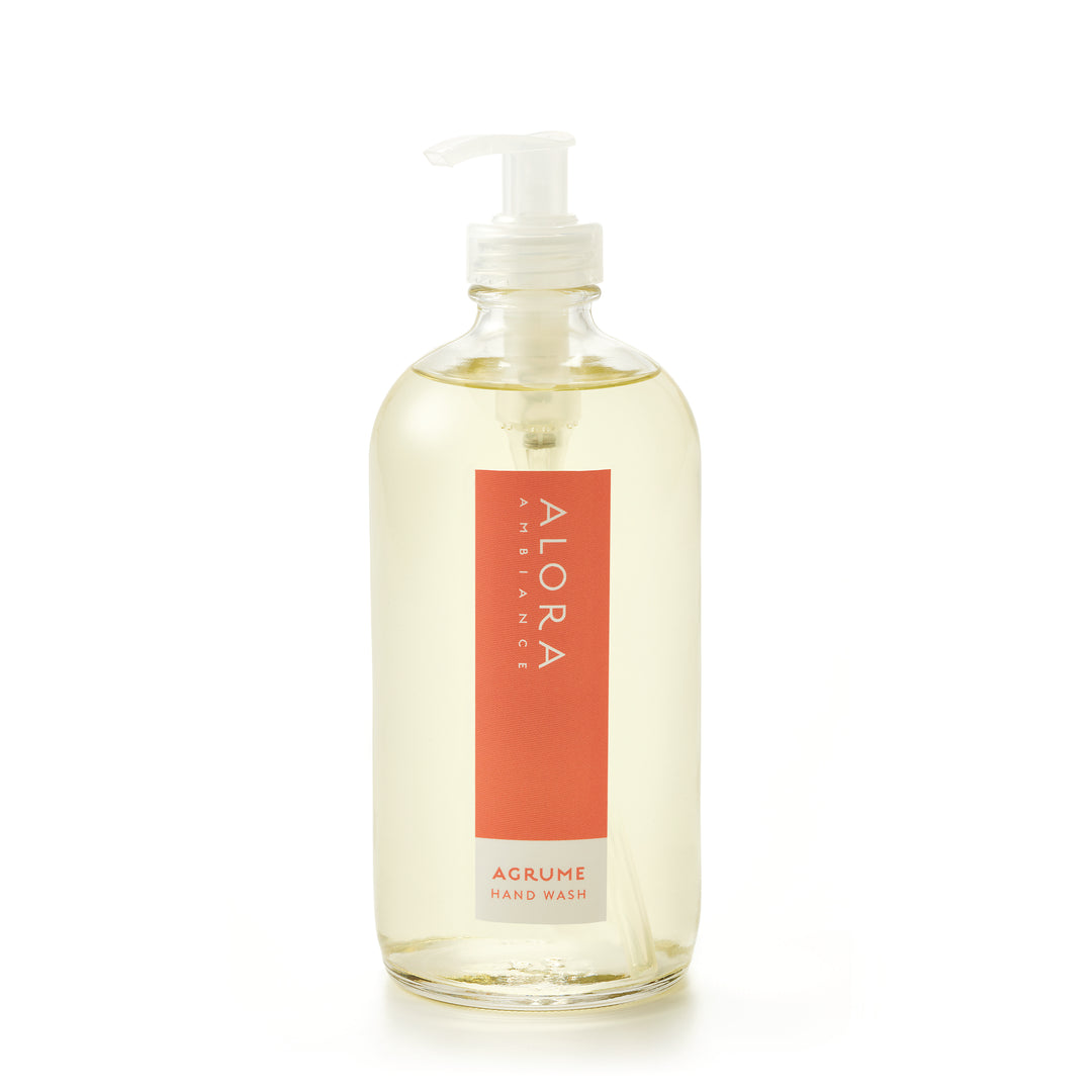 Tall glass bottle topped with a plastic pump and filled with clear, liquid hand wash with label that says “Alora Ambiance” and “Agrume Hand Wash” on the front