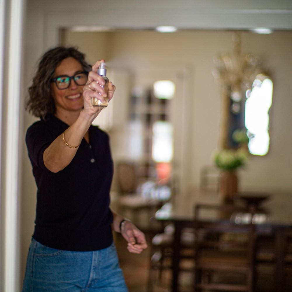 Woman spritzing room spray in dining room