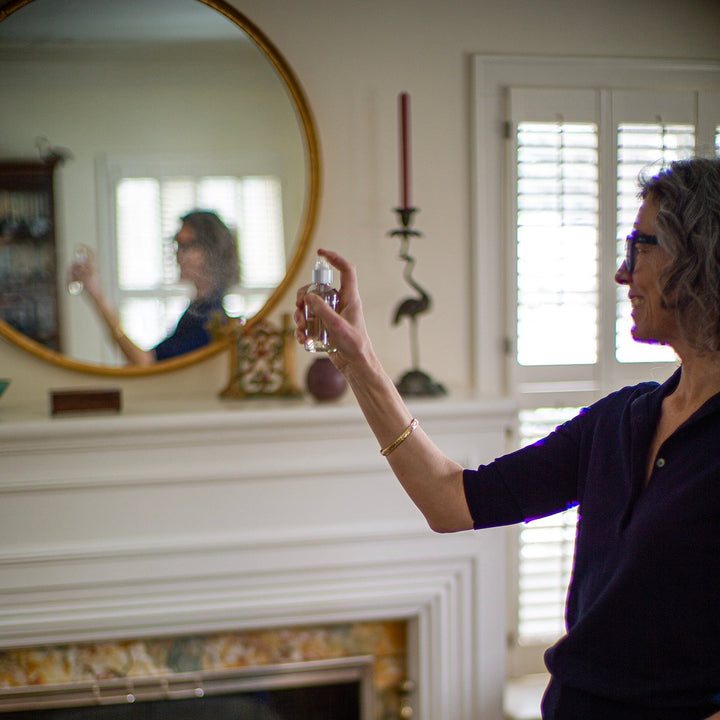 Woman spraying room spray in a living room