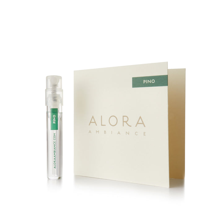 Small clear plastic vial that says “Alora Ambiance” and “Pino” next to a tan card that also says “Alora Ambiance" and “Pino”