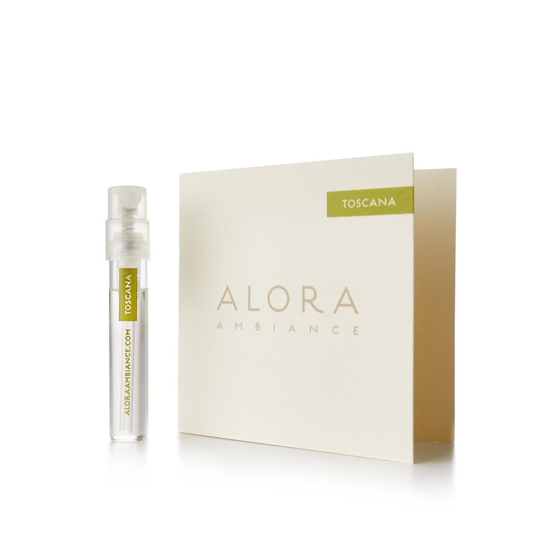 Small clear plastic vial that says “Alora Ambiance” and “Toscana” next to a tan card that also says “Alora Ambiance" and “Toscana”