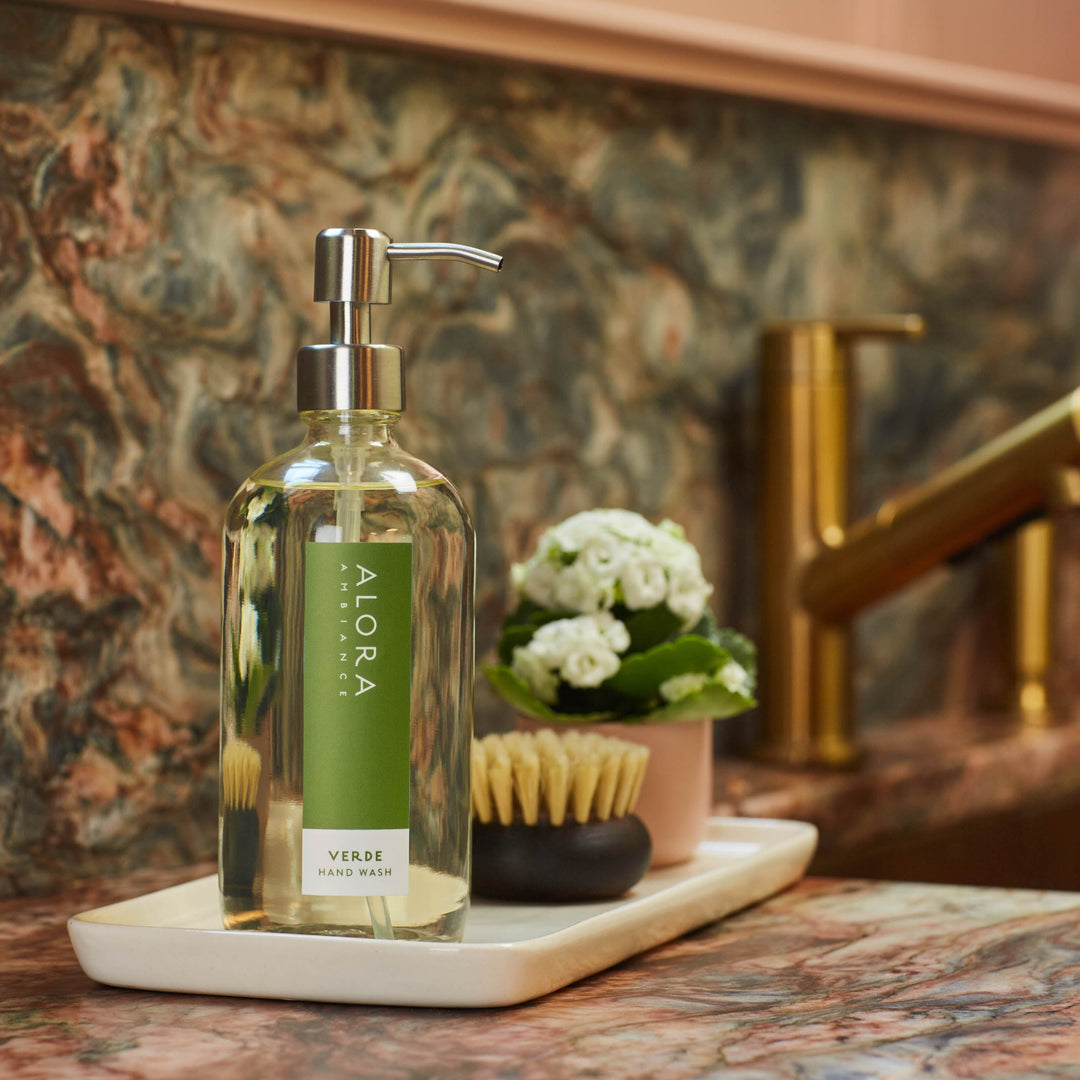 Verde hand wash bottle sitting on a tray on a granite countertop next to a kitchen sink