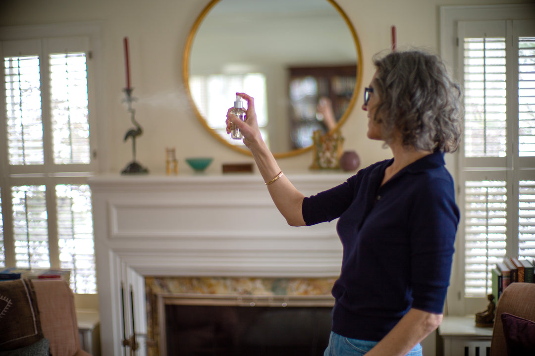 Woman spraying a room spray in living room