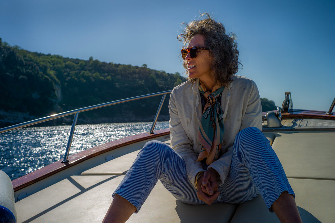 Woman sitting on the front of a boat on the ocean