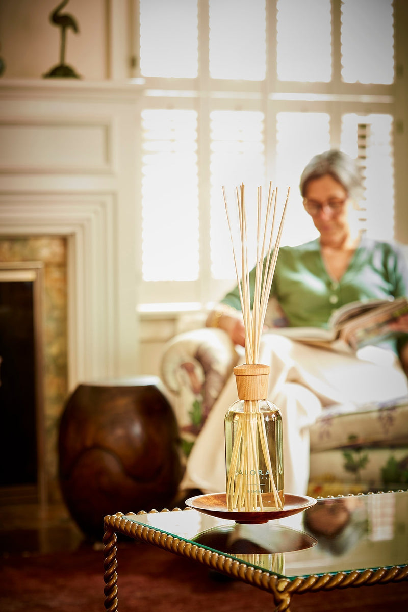 Luxury reed diffuser styled in a living room with Therese in the background