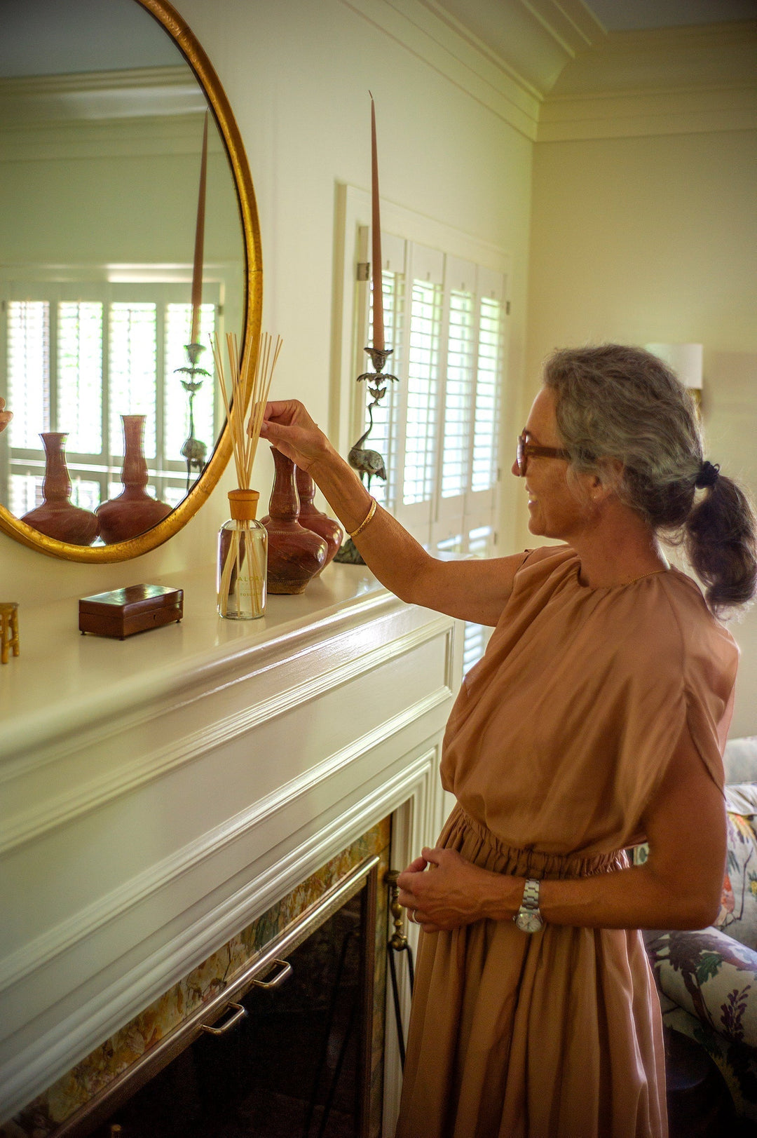 therese adjusting reed diffuser in her living room