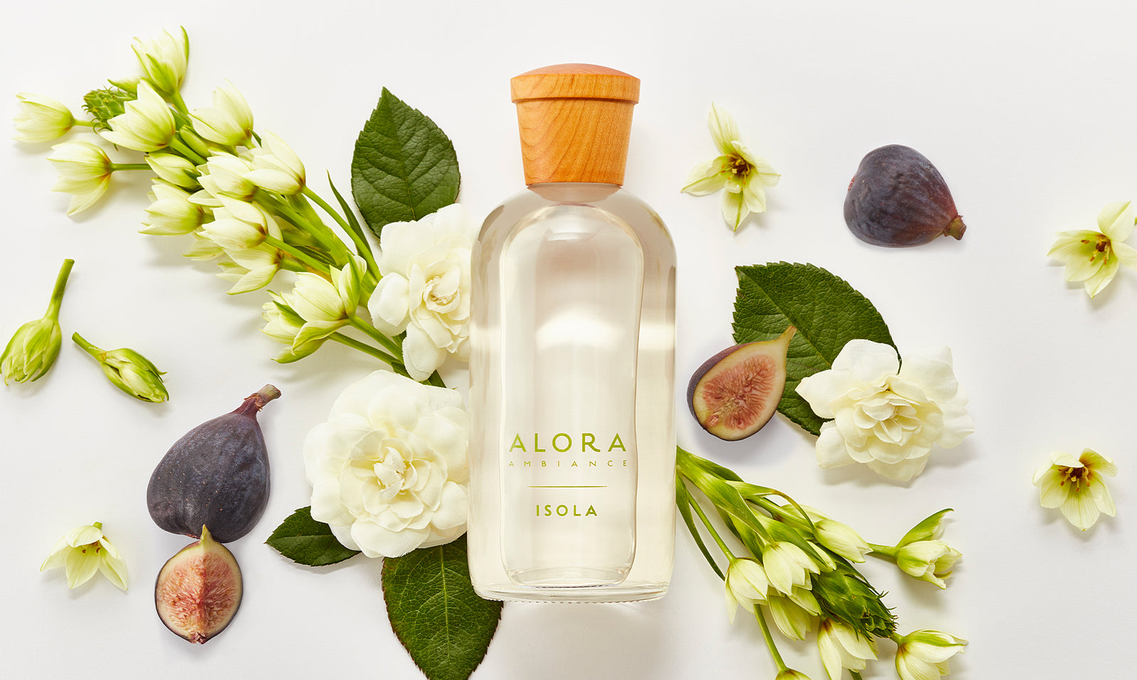 Isola diffuser bottle next to fresh figs and gardenia and tuberose flowers