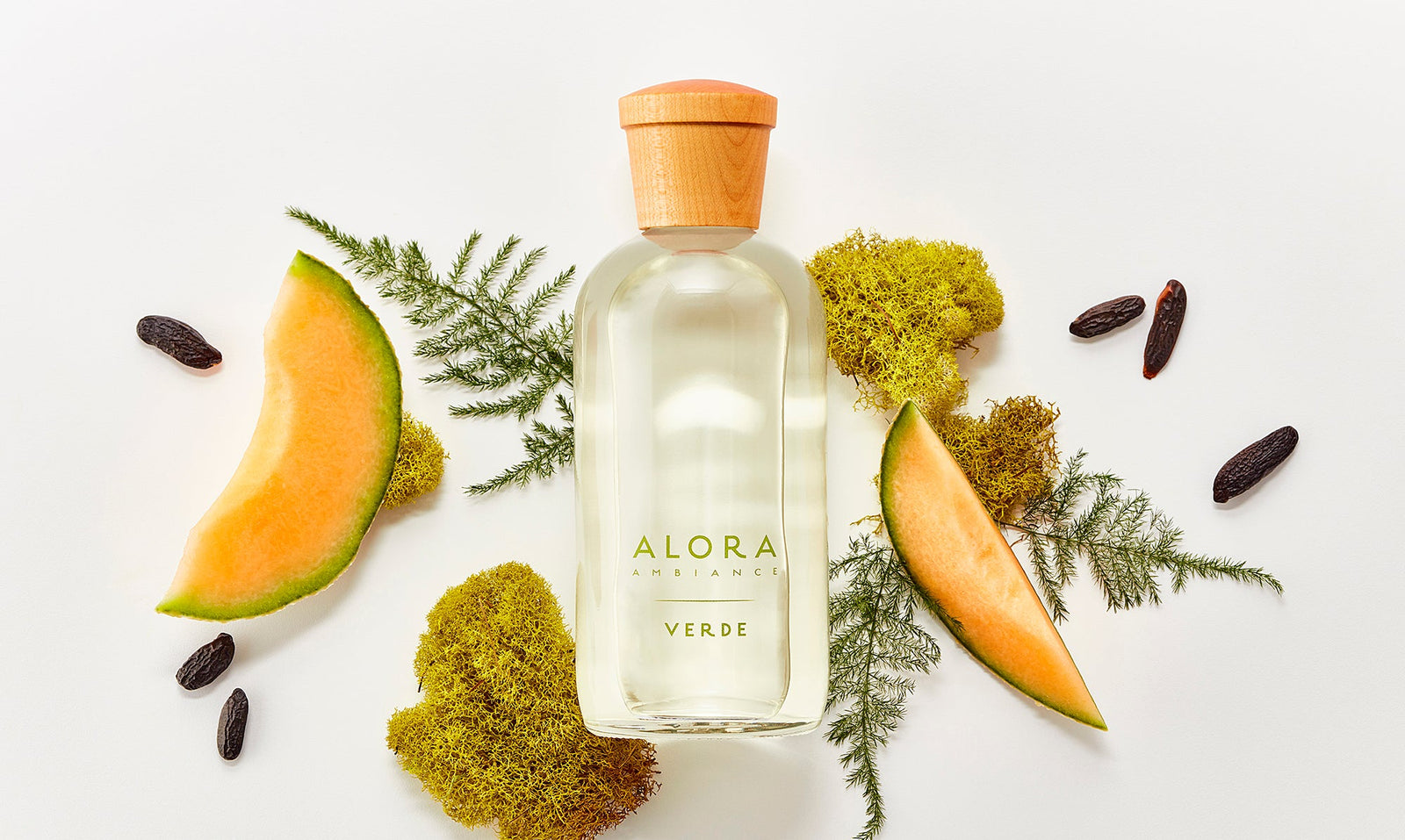 Verde diffuser next to fresh cantaloupe slices, moss, and tonka beans