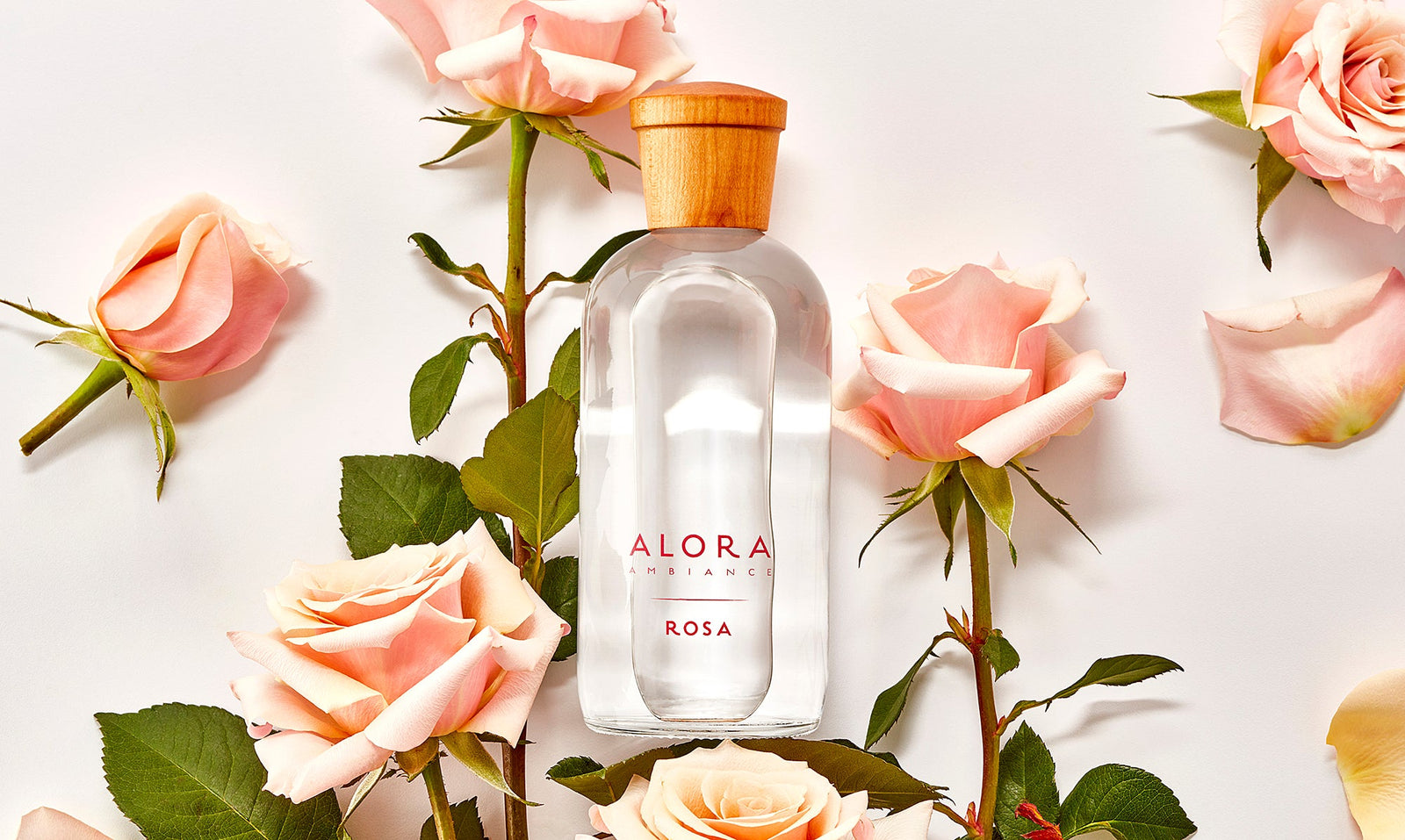 Rosa diffuser bottle surrounded by pink roses