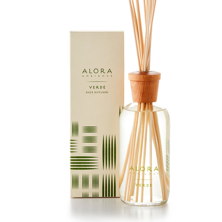 Alora Ambiance 16oz Verde reed diffuser with glass bottle and wooden cap next to tan box with a green striped pattern on it.