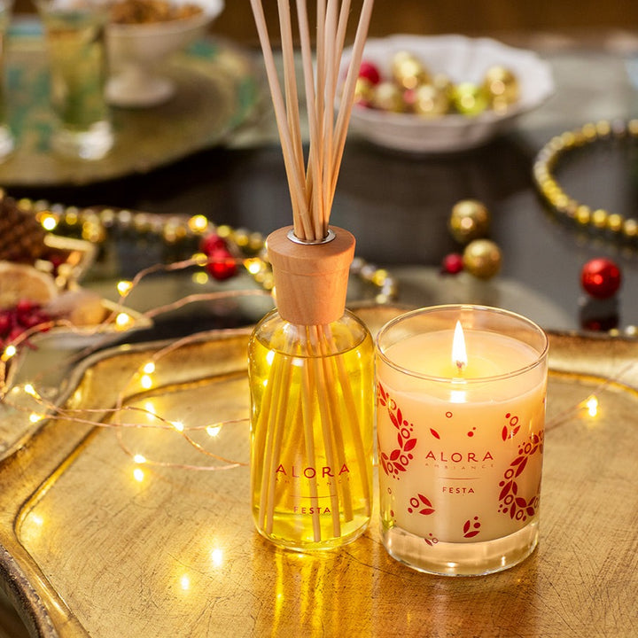 Festa diffuser on a gold tray next to a lit Festa candle