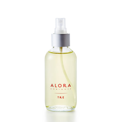 Glass spray bottle with the words "Alora Ambiance" and "Tre" written in brown font on the front