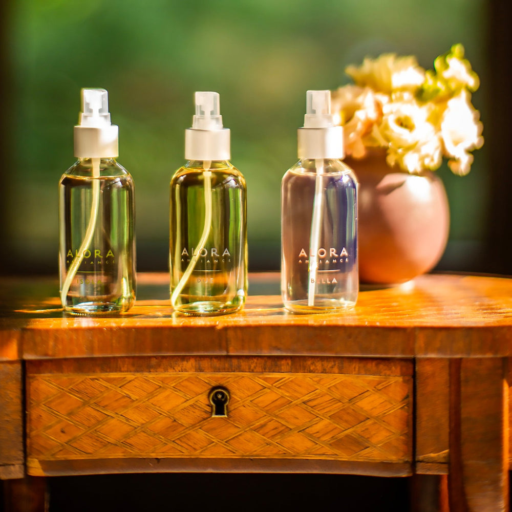 Isola, Due and Bella room spray bottles sitting on wooden end stand
