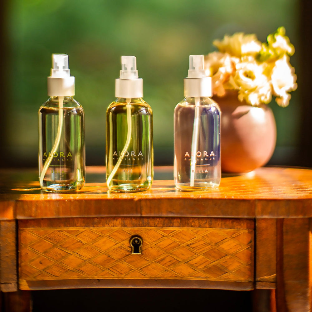 Isola, Due, and Bella room sprays on a wooden end stand