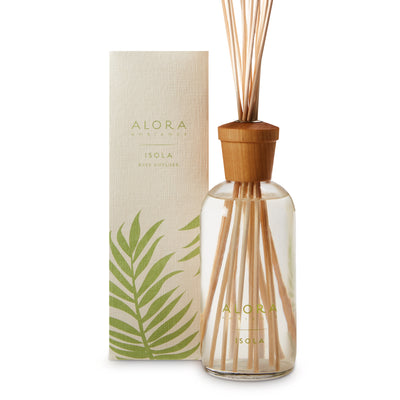 Glass bottle filled with clear, liquid fragrance, topped with wood cap with reeds passing through cap into liquid. Bottle says “Alora Ambiance” and “Isola” and is by a tan box 