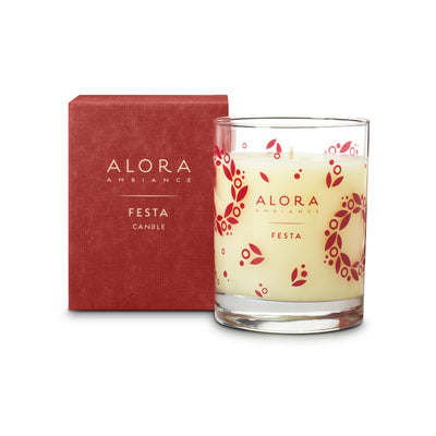 Cream-colored candle in glass jar that says “Alora Ambiance” and “Festa” and is next to a red box that says “Alora Ambiance” and “Festa candle”