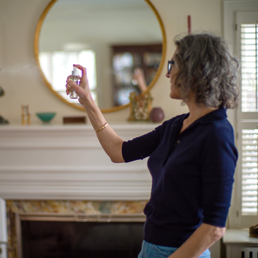 Woman spritzing a room spray in the living room