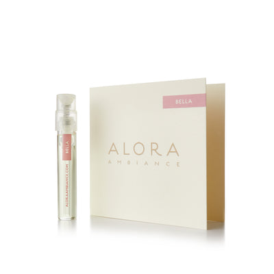 Small clear plastic vial that says “Alora Ambiance” and “Bella” next to a tan card that also says “Alora Ambiance" and “Bella”