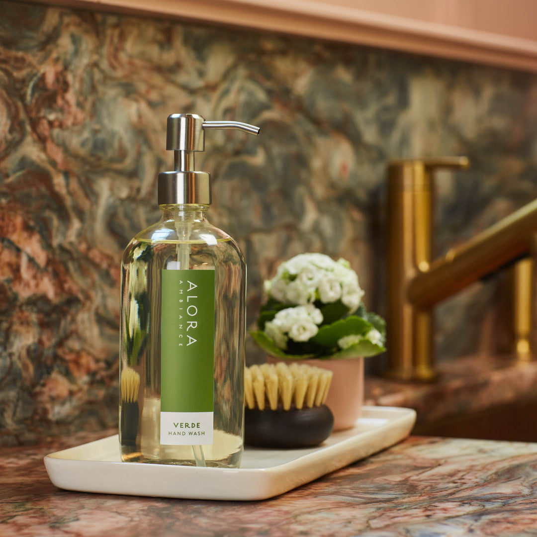 Verde hand wash bottle on a white porcelain tray next to kitchen sink.